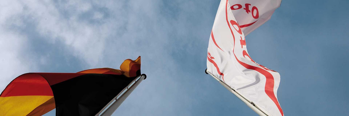 A Roto vállalati zászló és a német zászló lengedezik a szélben