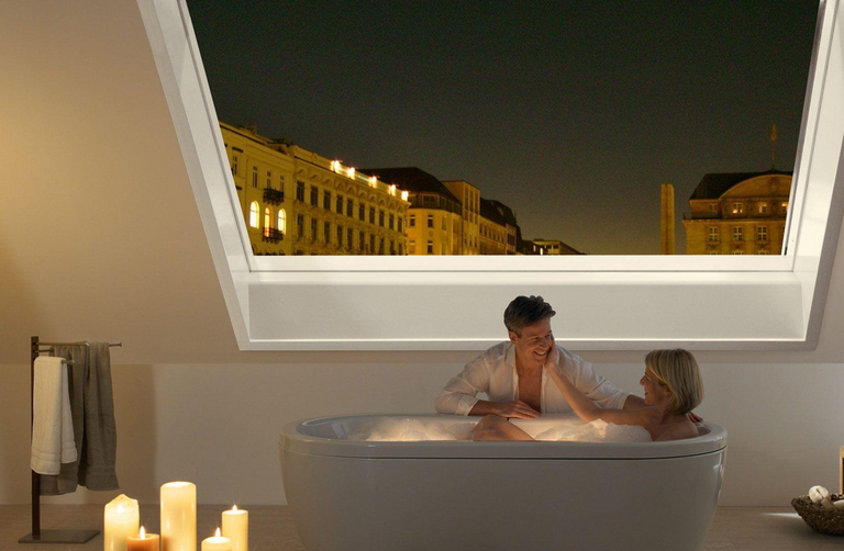 Una finestra panoramica per tetti Azuro aperta sul cielo notturno crea un'atmosfera romantica nel bagno