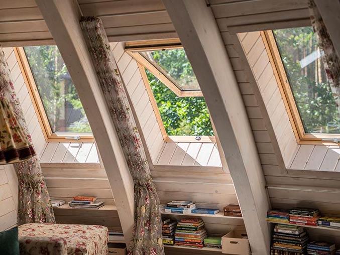 Hangulatos olvasósarok egy faházban, fa tetőablakokkal
